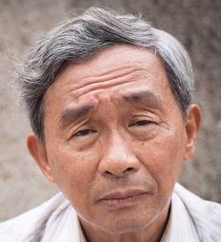 Photo of a man with a white shirt and a furrowed brow
