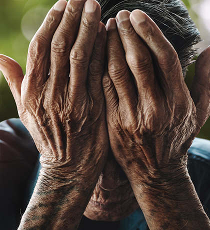 Photo of hands covering a person's face