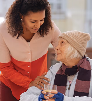 Photo of a woman comforting another in beanie and scarf