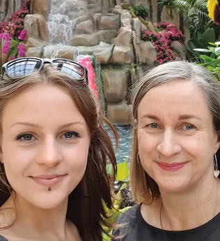 Photo of two smiling women at a water feature