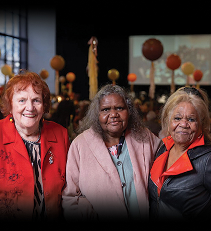 Photo of three women standing together and smiling