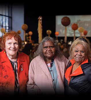 Photo of three women standing together and smiling