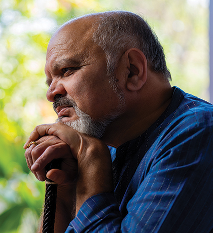 Photo of a bearded man leaning on his walking stick