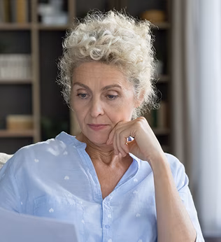 Photo of a woman wearing a blue blouse reading a letter