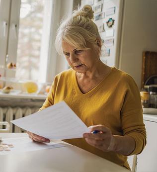 Photo of woman in yellow doing paperwork