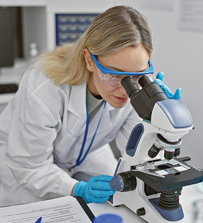 Photo of a scientist peering into a microscope