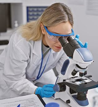 Photo of a scientist peering into a microscope