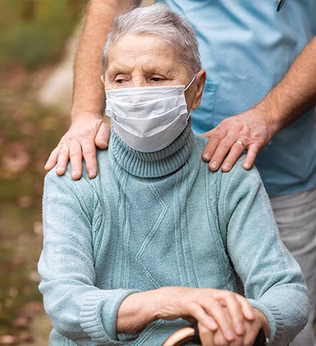 Photo of a woman in a pale green jumper wearing a mask