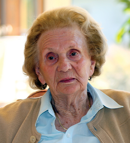 Photo of a sad woman in a pale blue shirt and beige cardigan