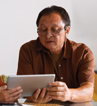Photo of two people wearing earth tones looking at a computer tablet