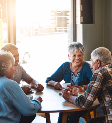 Image of a group of older people having a coffee at a round table