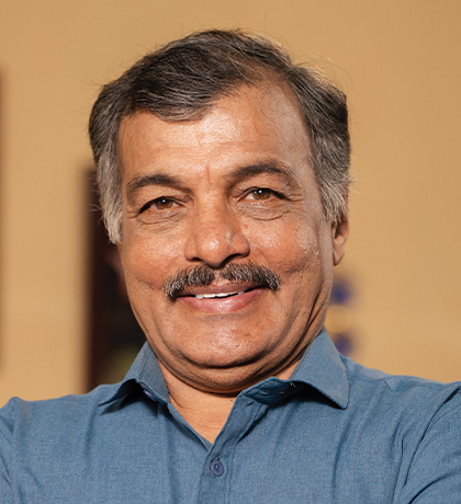 Photo of a smiling man in a blue grey shirt