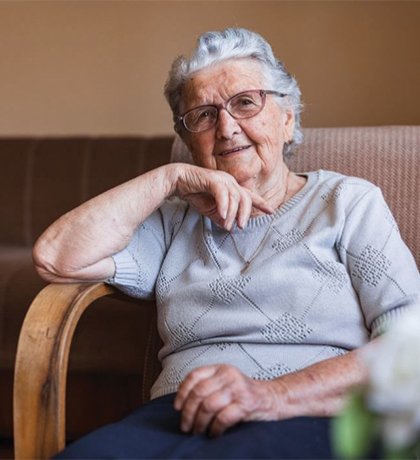 Photo of a smiling woman sitting in an arm chair