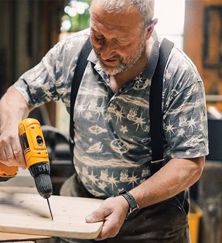 Photo of man using a drill in a workshop