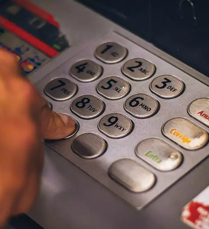 Photo of a finger pressing buttons on an ATM