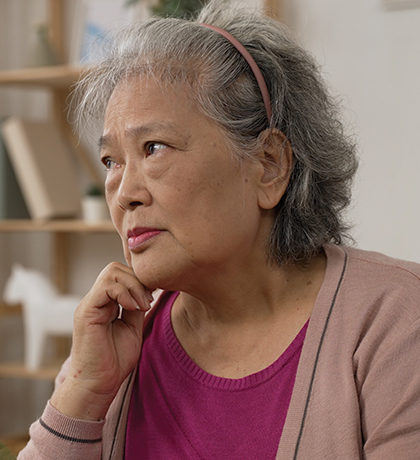 Photo of a woman in a fuchsia blouse and dusty pink cardigan