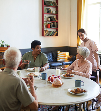 Photo of a group of people having tea and croissants round a table