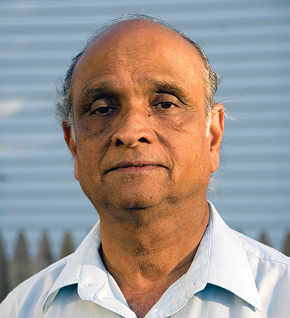 Photo of a man standing in front of a picket fence