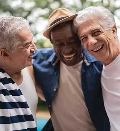 Photo of three men embracing and laughing together