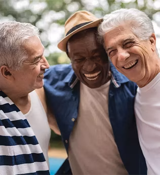 Photo of three men embracing and laughing together