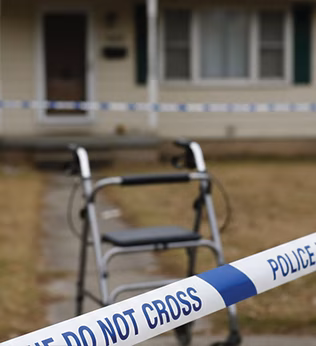 Photo of police crime tape with a walker in the background