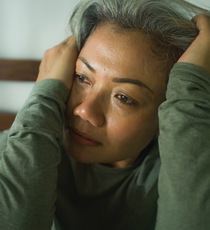 Photo of a woman in a sage green top with hands