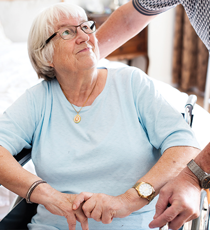 Photo of a woman in a baby blue t-shirt sitting in a wheelchair