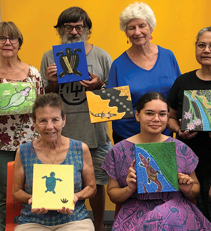Photo of a group holding artworks