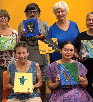 Photo of a group holding artworks