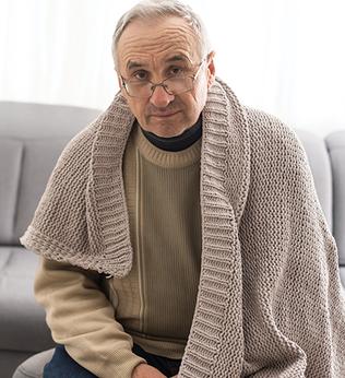 Photo of a man wearing a beige knit shawl