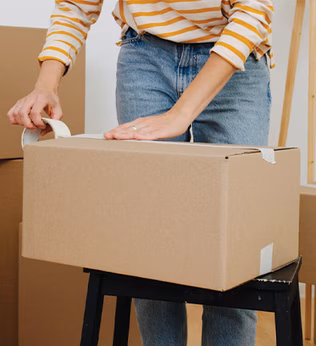Photo of person packing cardboard boxes