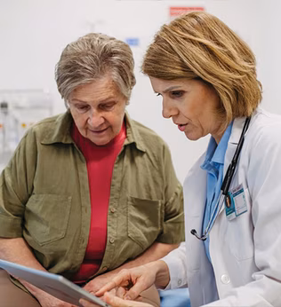 Photo of a doctor an patient looking at a computer tablet together