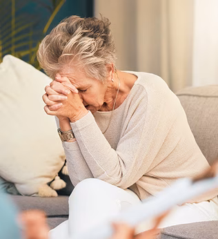 Photo of a woman in distress resting her head on her hands