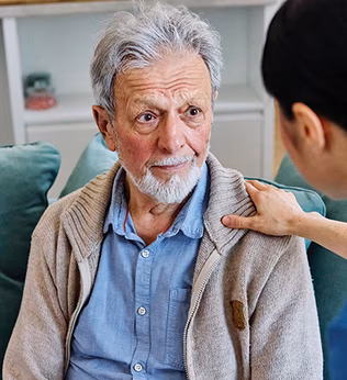 Photo of a health worker's hand on a man's shoulder