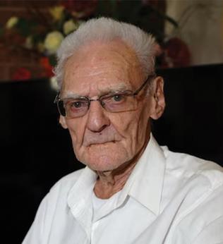 Photo of a man wearing glasses and a white shirt