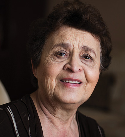 Photo of woman smiling on a taupe sofa