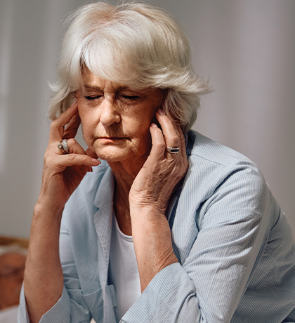 Photo of a woman with white hair wearing a pale blue jacket