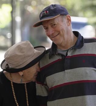 Photo of a woman with a hat and a man wearing a cap