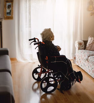 Photo of a woman in a room in a wheelchair