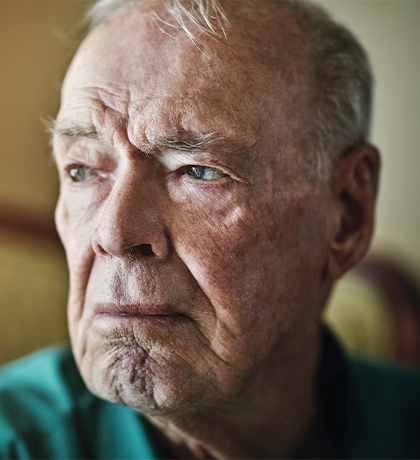 Photo of a man in a green shirt looking sad