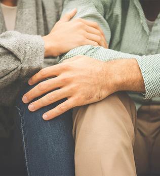 Image of two people holding each other on the knee and arm