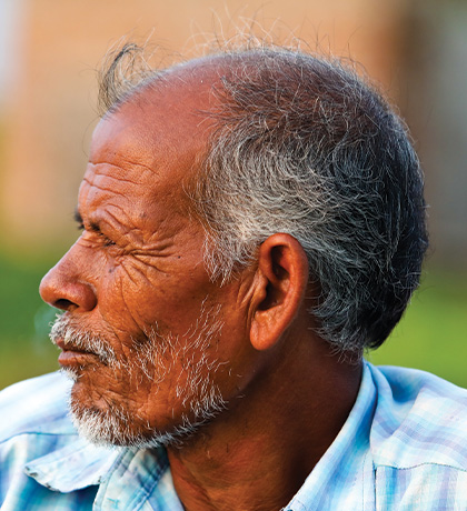 Photo of a man wearing a pale blue plaid shirt
