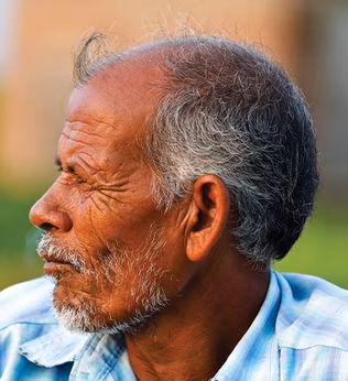 Photo of a man wearing a pale blue plaid shirt