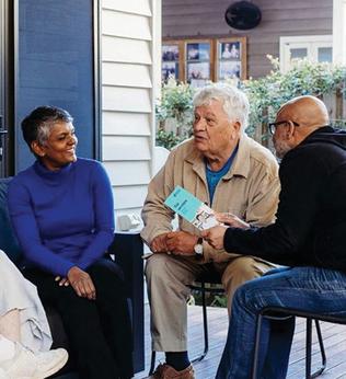 Photo of a group of older people having a meeting on a verandah