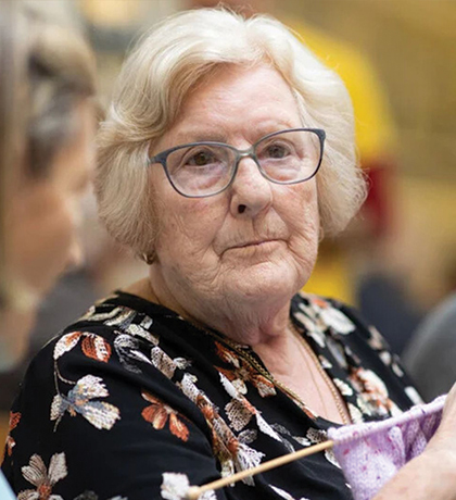 Photo of a woman wearing glasses and knitting