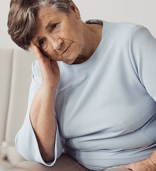 Photo of seated woman with her head on her hand