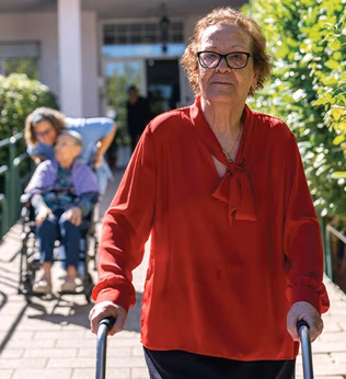 Photo of a woman in a red blouse walking outside