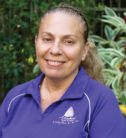 Photo of a smiling woman wearing a purple polo shirt