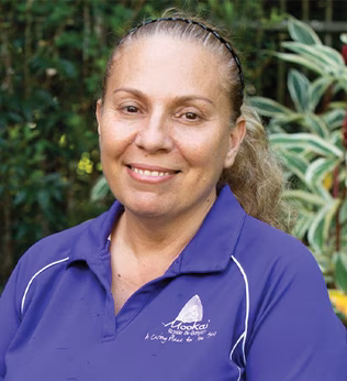 Photo of a smiling woman wearing a purple polo shirt
