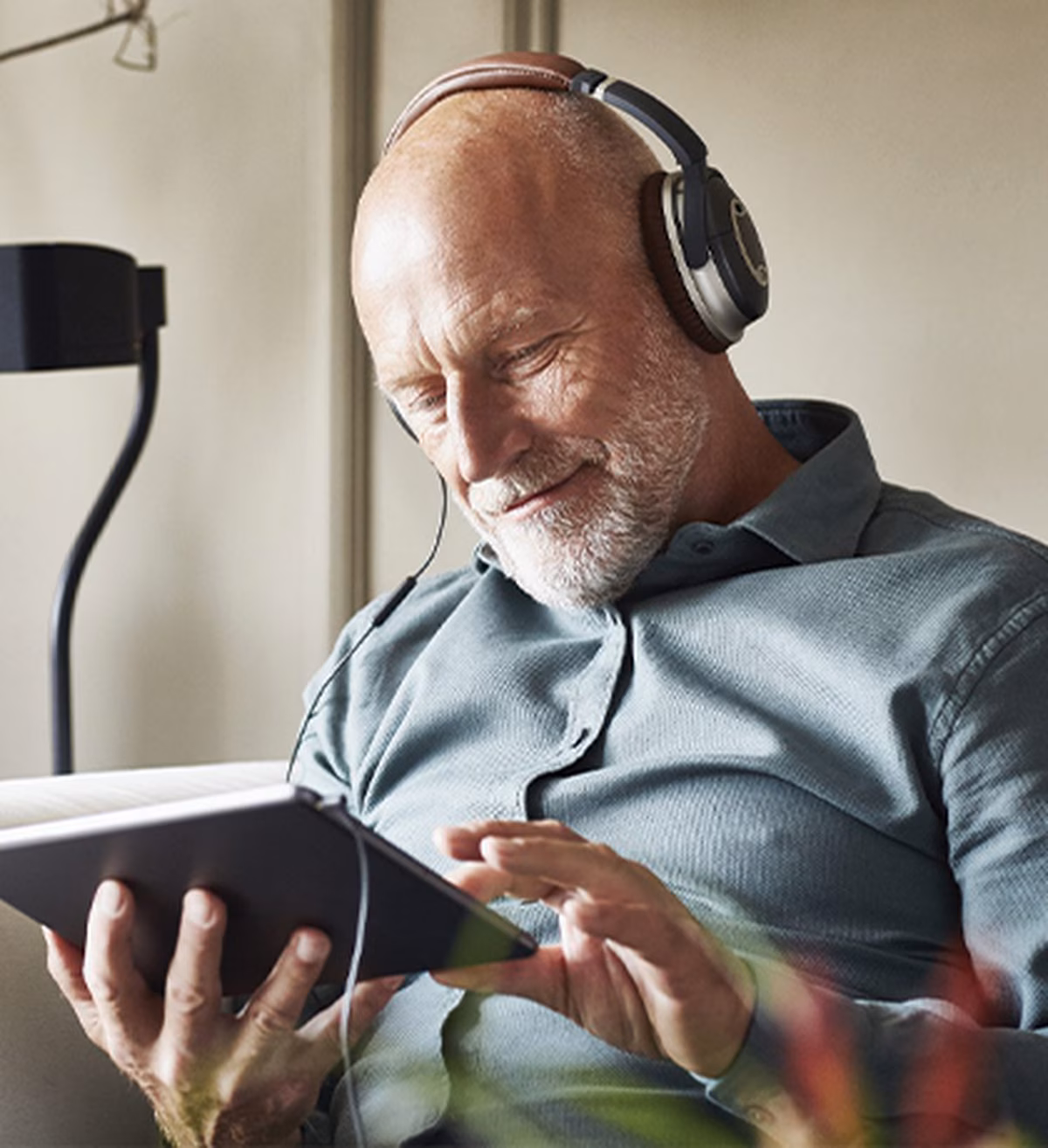 Image of an older man listening to a podcast